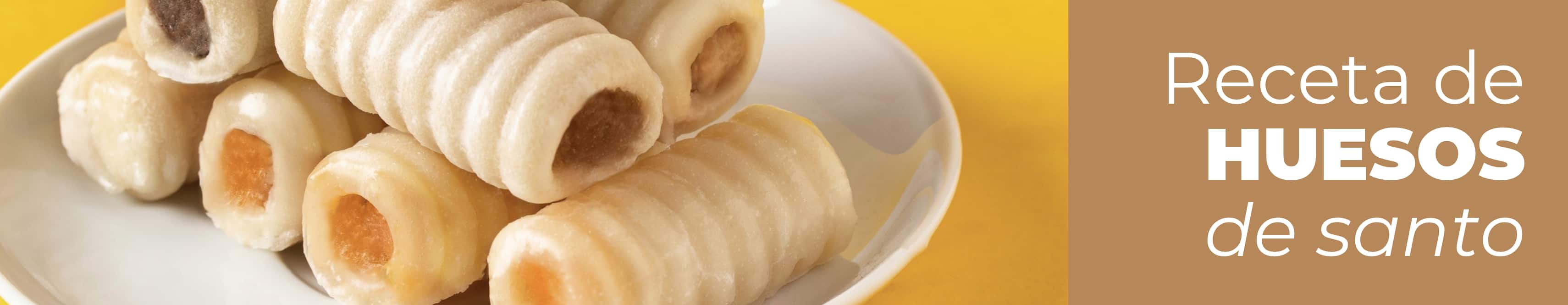 Huesos de santo tradicionales de mazapán y yema listos para servir en un plato.